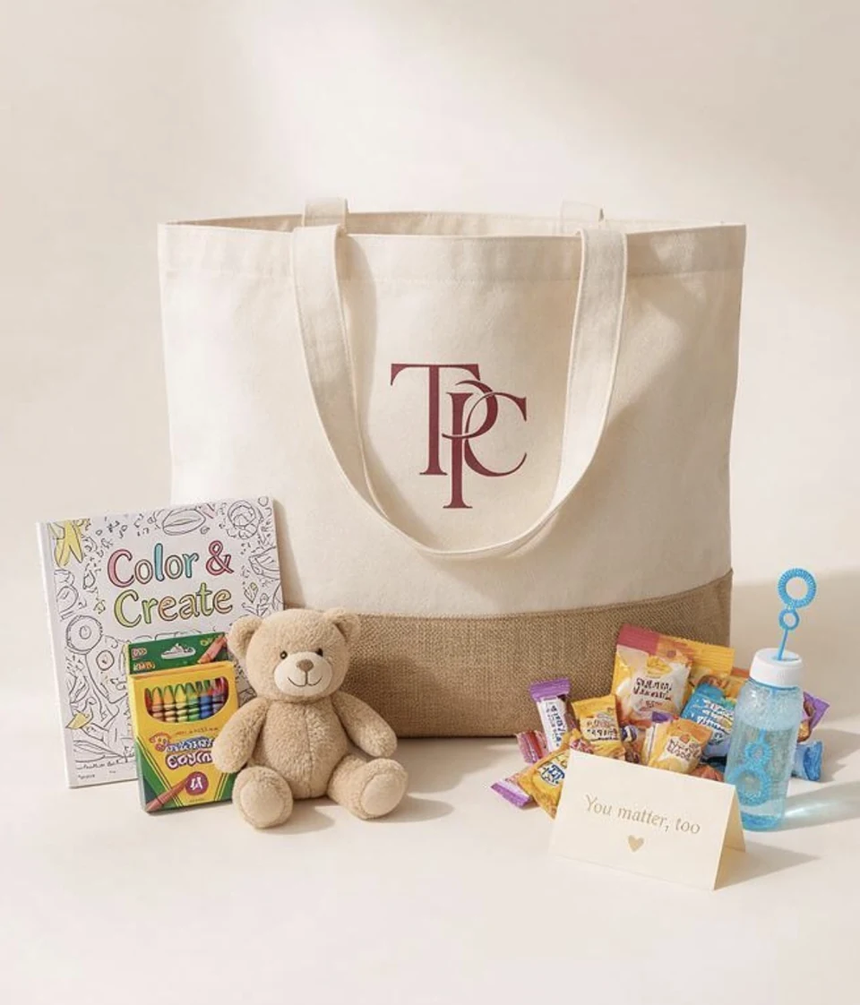 The Carry Project sibling tote with a teddy bear, coloring book, crayons, snacks, and bubbles.
